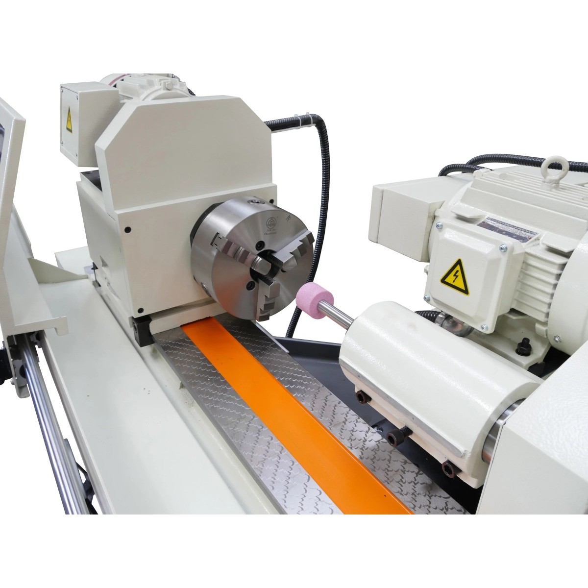 Rundschleifmaschine Modell CG 1000 (Symbolfoto) Detailansicht einer Rundschleifmaschine mit Spannfutter, Schleifspindel, Schleifstein und Antriebsmotor.