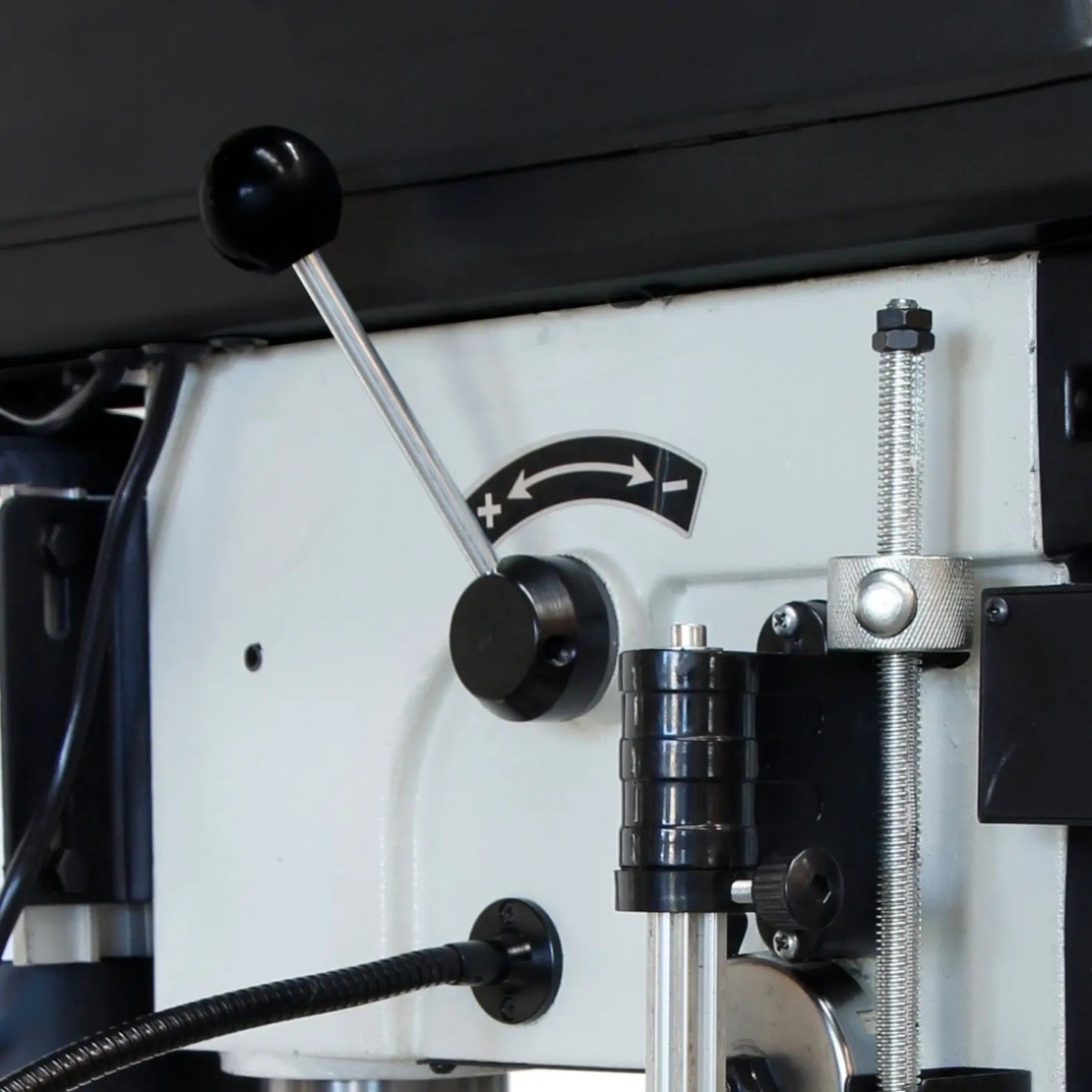 Keilriemen-Tischbohrmaschine Modell KBM 16 T VARIO Nahaufnahme des Verstellhebels der ELMAG Tischbohrmaschine KBM 16 T VARIO mit Plus-Minus-Markierung, Gewindestange und Halterung.