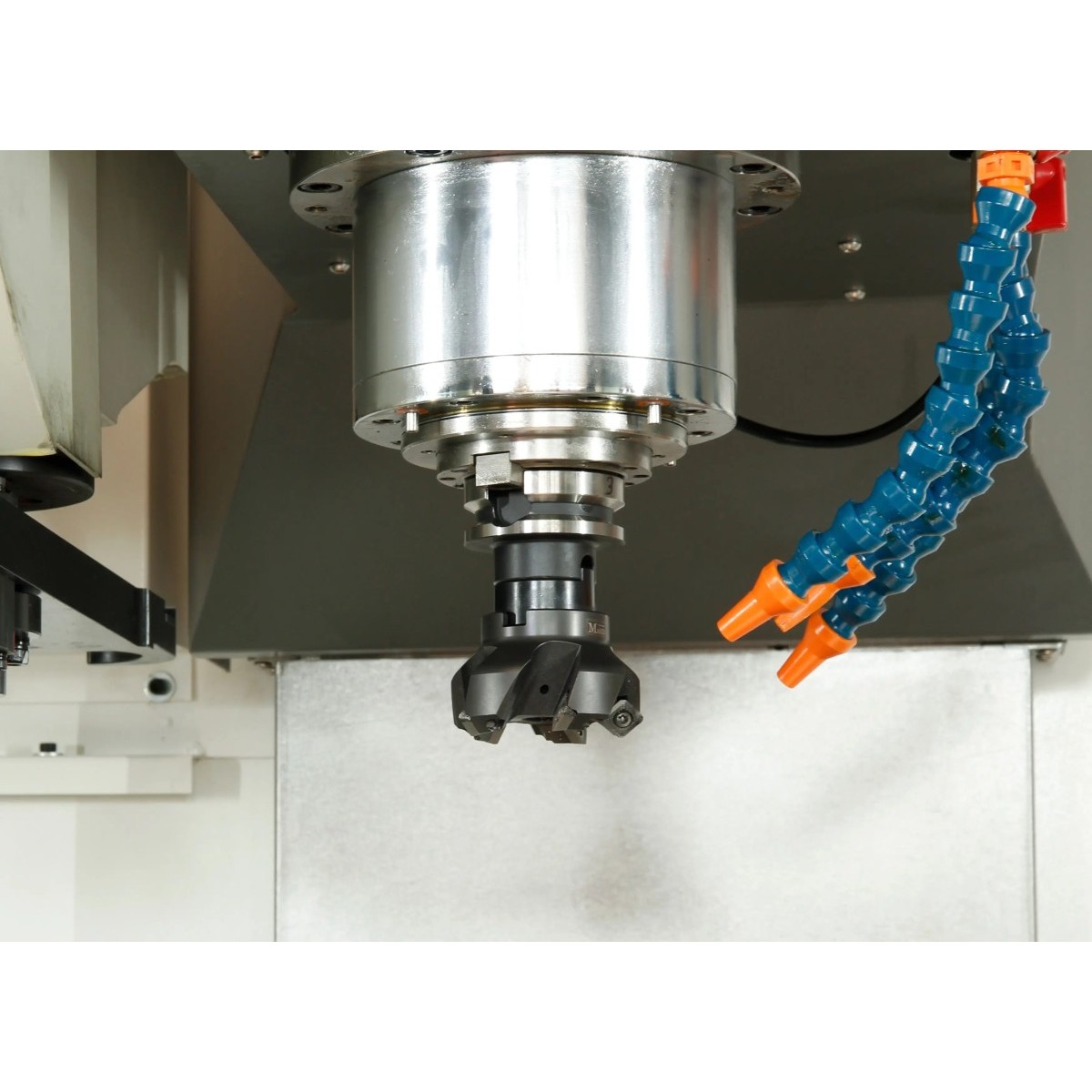 Detailansicht einer CNC-Frässpindel mit eingespanntem Fräswerkzeug und zwei Kühlmitteldüsen.