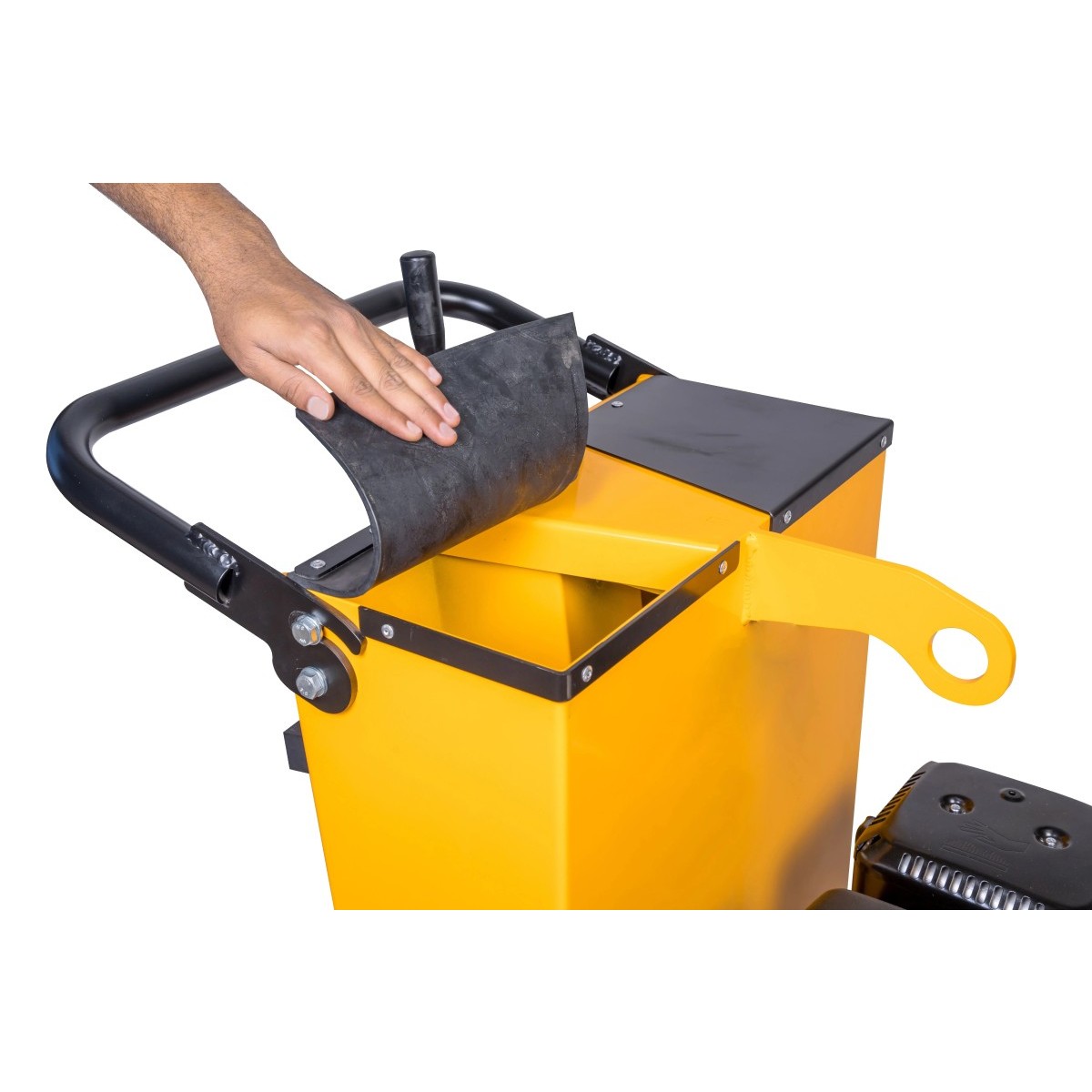 Hand legt schwarze Gummimatte auf den geöffneten Wassertank einer gelben Fugenschneidemaschine.