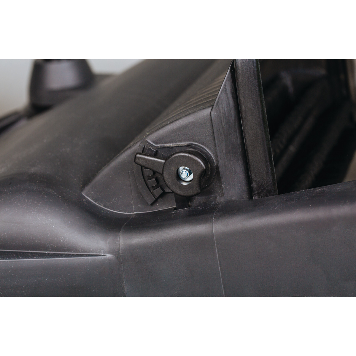 Handkehrmaschine HKM 800 Detailaufnahme einer seitlichen Einstellungsschraube am Gehäuse der Kehrmaschine.