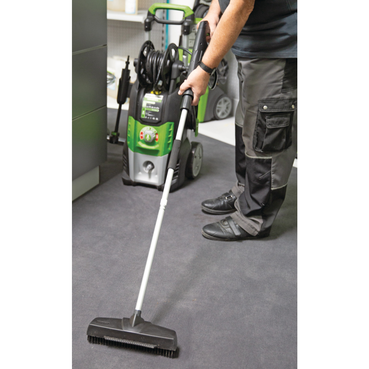 Kaltwasser-Hochdruckreiniger HDR-K 85-16 TF Anwendungsbild: Person reinigt mit Hochdruckreiniger und Bodenaufsatz eine Oberfläche im Innenbereich.