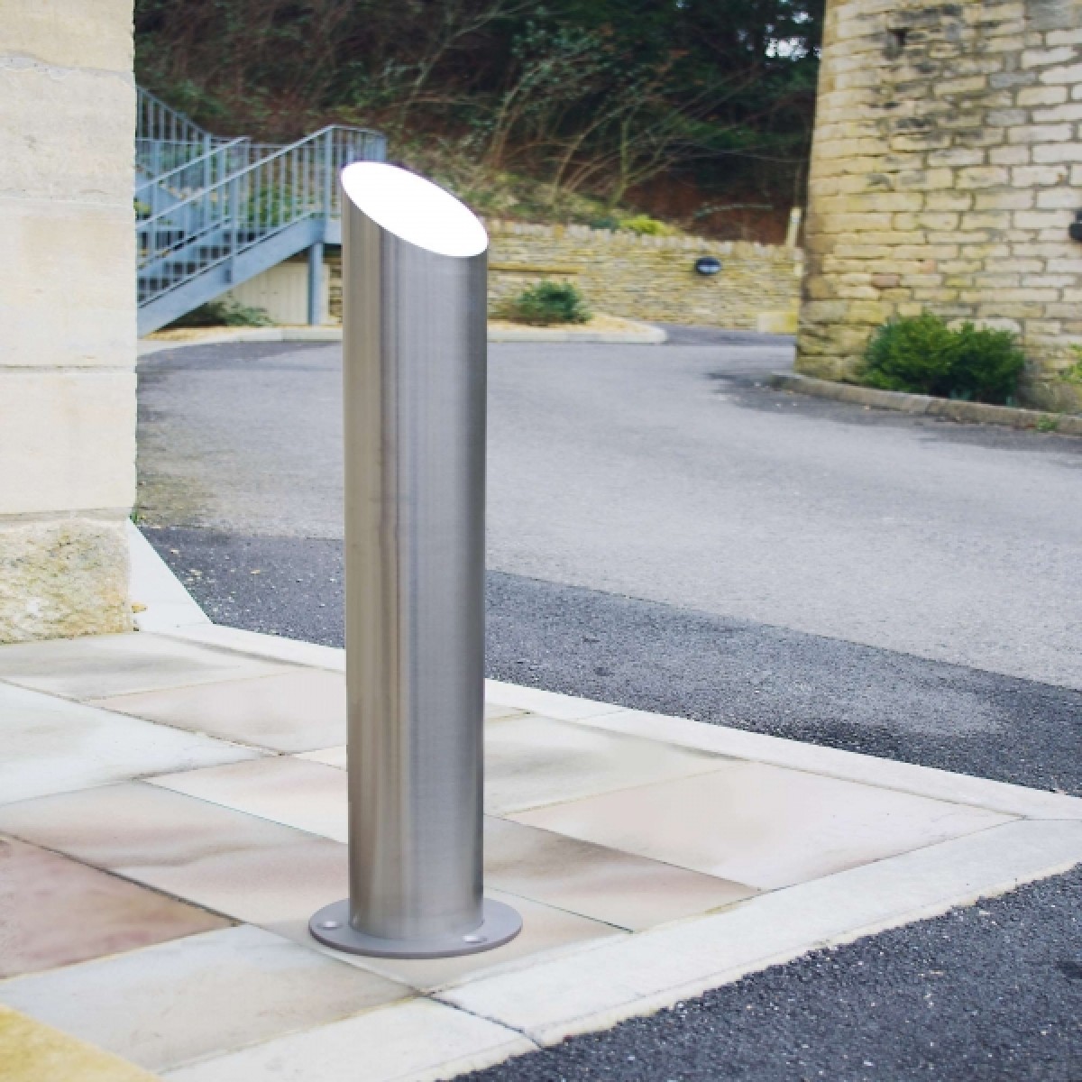 Technische Skizze: Poller mit schrägem Kopf im Fundament, 900 mm über Boden, 300 mm Einbautiefe.