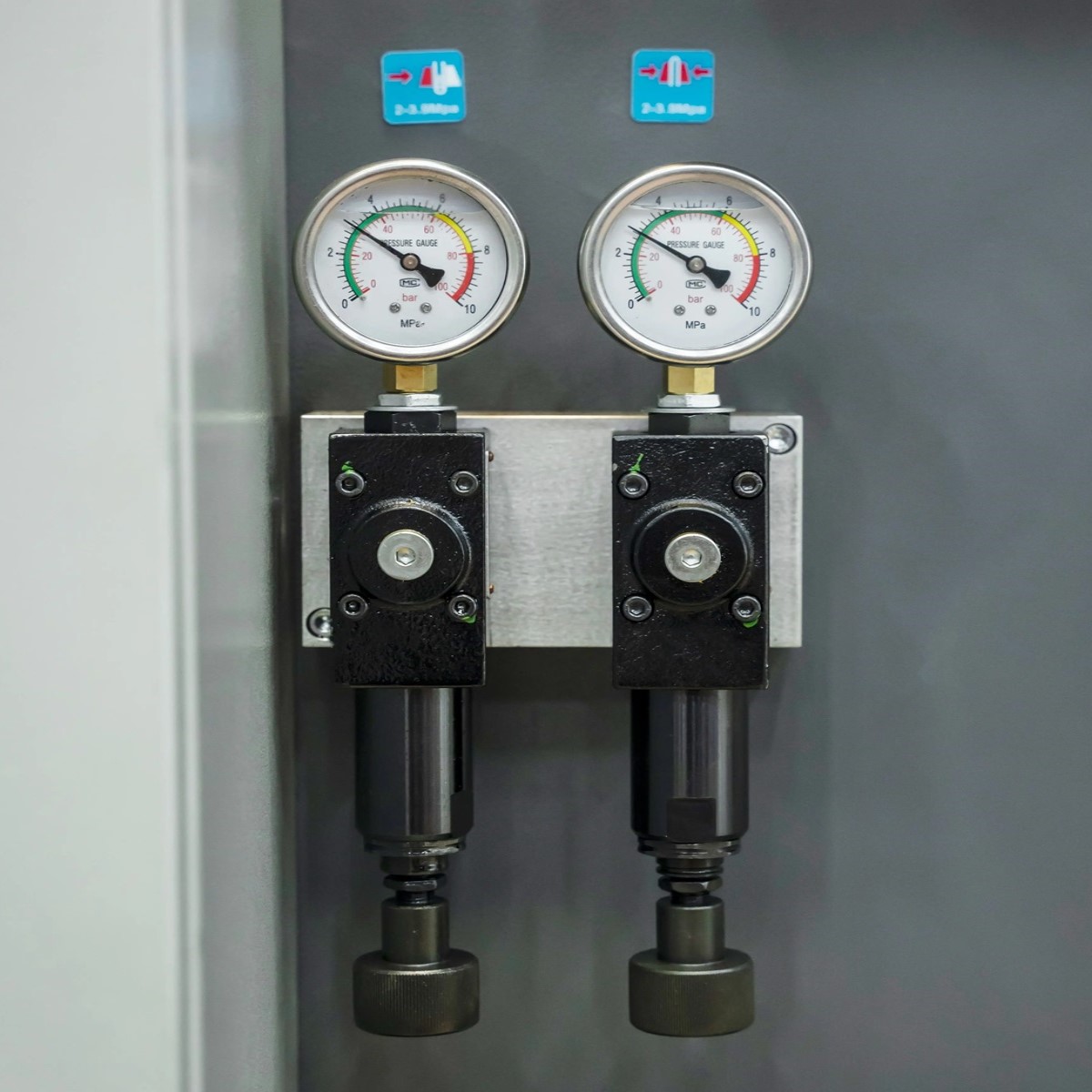 Detailansicht mit zwei Manometern und Druckreglern zur Einstellung von Spann- und Hydraulikdruck.
