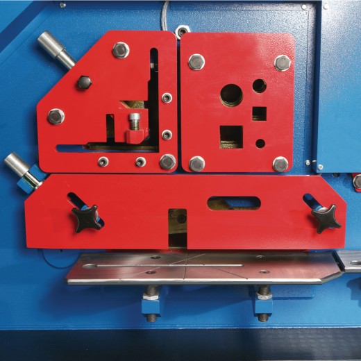 Hydraulische Profilstahlschere/Lochstanze HPS 85 DS Werkzeugmodul mit mehreren roten Einsätzen und Aussparungen für verschiedene Schnitte.