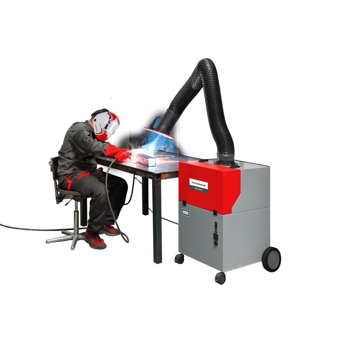 Schweißer sitzt am Tisch und arbeitet; Absauggerät mit flexiblem Arm erfasst Rauch am Werkstück.