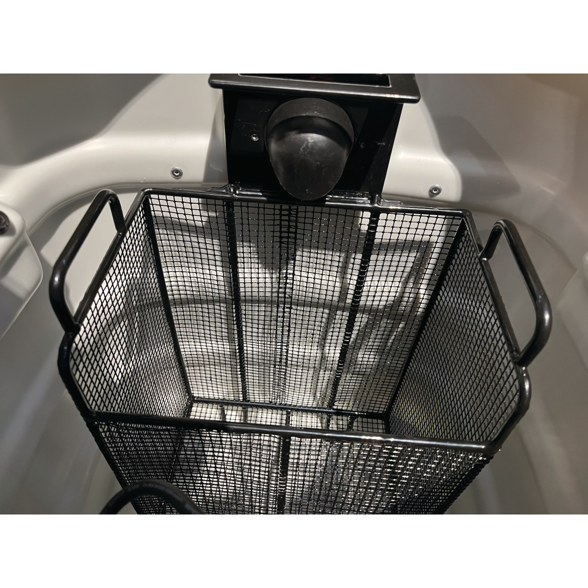 Innenansicht des Behälters mit eingesetztem rechteckigem Drahtkorb unter der Ansaugöffnung.