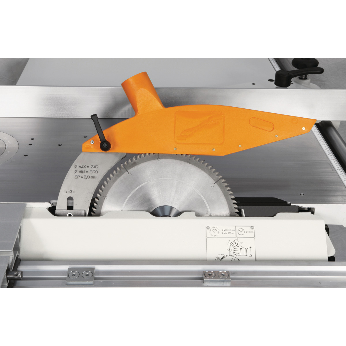 Formatkreissäge minimax sc 3c 23 Kreissägeblatt mit orangefarbener Schutzhaube, Spaltkeil und angrenzender Tischfläche der Maschine.