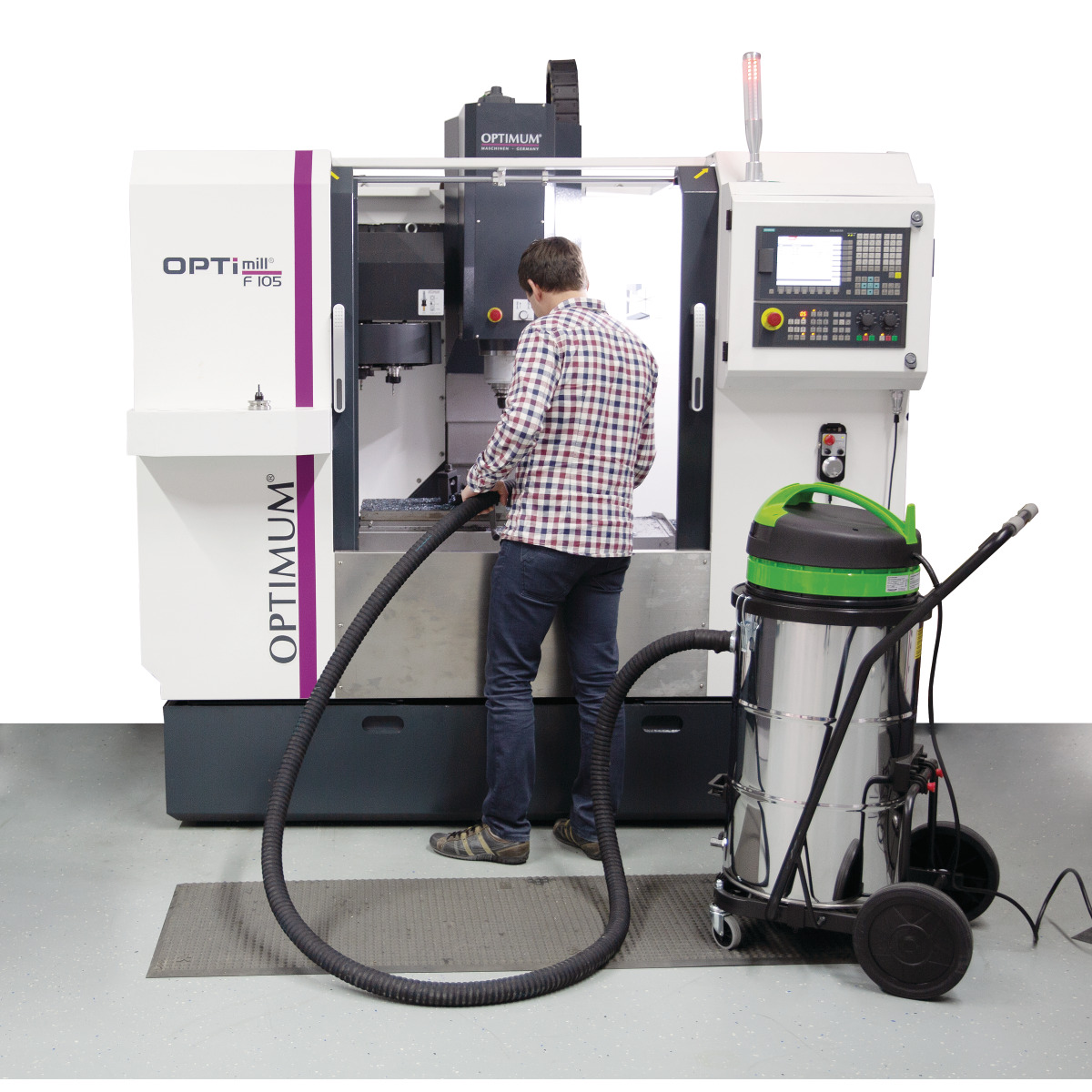 Nass-/Trockensauger flexCAT 378 EOT-PRO Mann saugt Metallspäne aus dem Arbeitsraum einer Fräsmaschine mit einem angeschlossenen Industriesauger.